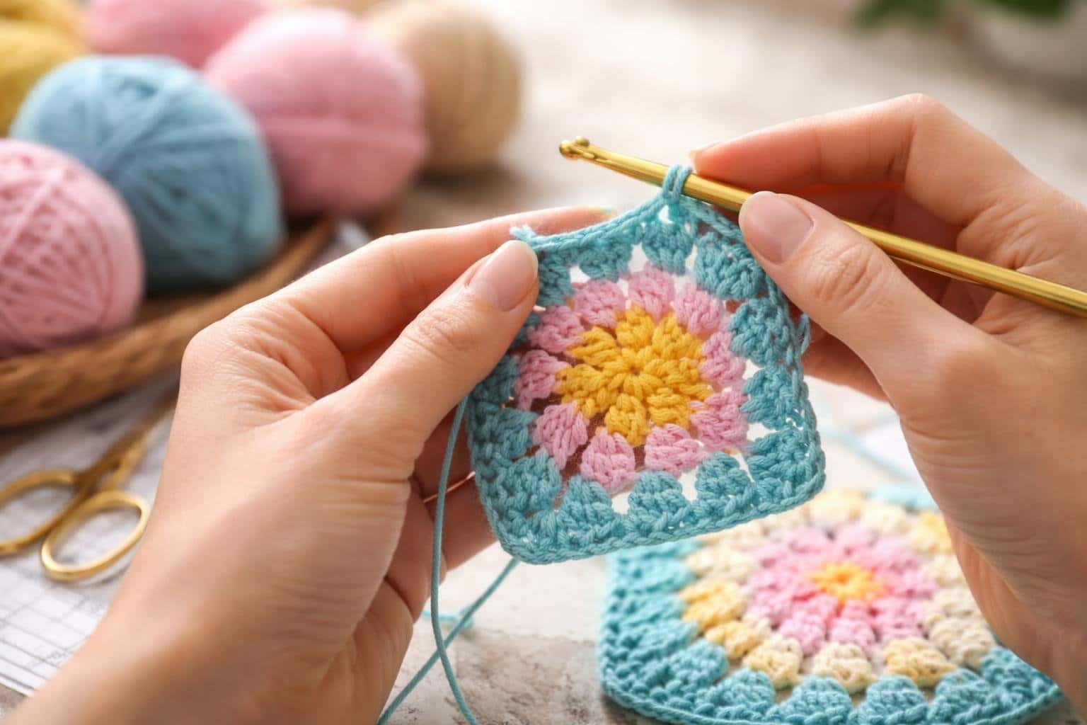 Mãos trabalhando em um quadrado (square) de crochê colorido com agulha e fios ao redor.